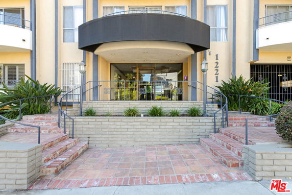 Front view of a multi-story building with a central entrance and steps leading up.