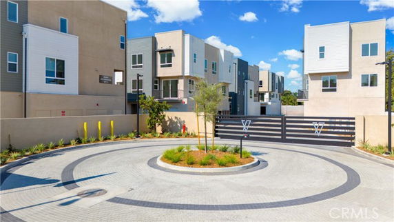 Front view of a modern townhouse complex with circular driveway.