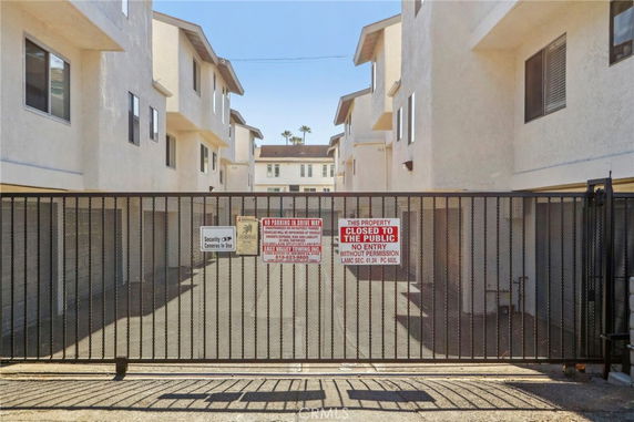 Gated entry to a residential parking area between multi-story apartment buildings