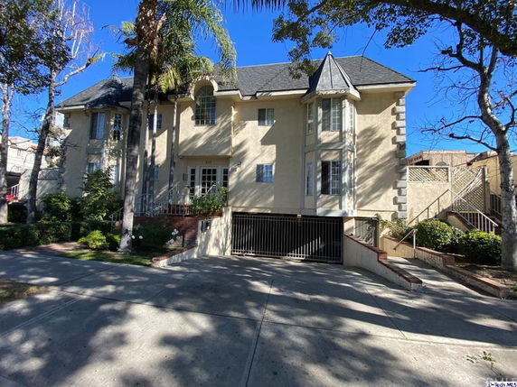Front view of a two-story building with a gabled roof and decorative windows.