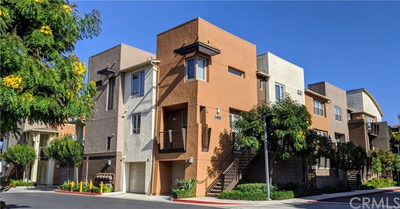 Front view of a modern multi-story residential building with balconies and large windows.