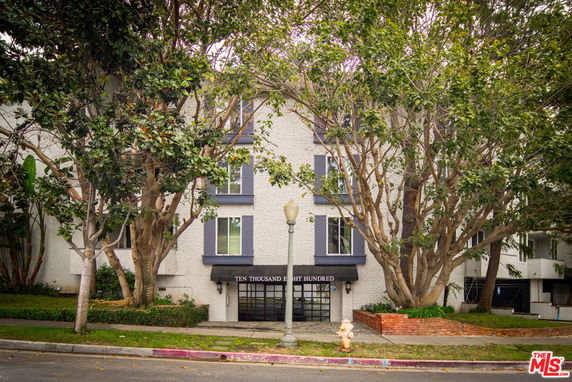 Front view of a multi-story building with trees in front.