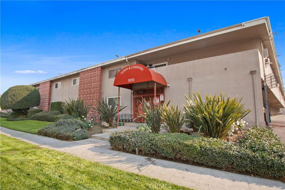 Front view of a two-story building with a red canopy entrance.
