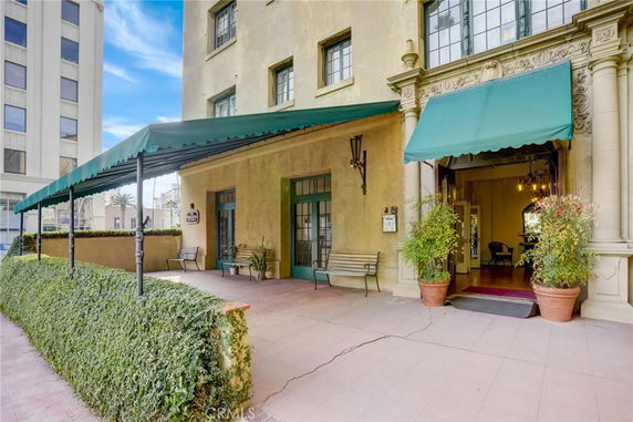 Front view of a multi-story building entrance with green awnings.