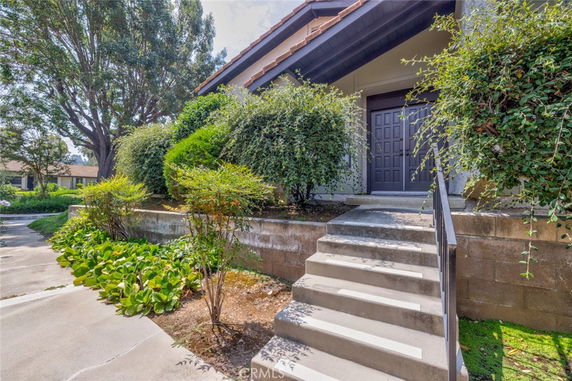 Front view of a house with a staircase leading to the entrance.