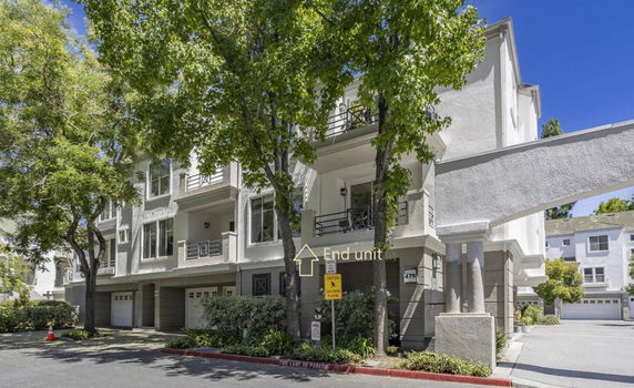 Front view of a multi-story residential building with balconies and garages.