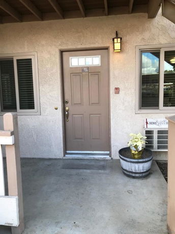 Front view of a building entrance with a brown door and windows on either side.