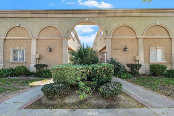 Front view of a building with arches and a single-story structure.