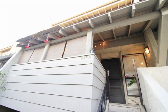 Front view of a two-story house entrance with a small balcony.