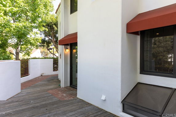 Partial view of a building with white walls and an orange awning.
