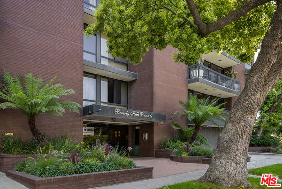 Front view of a multi-story building with balconies and a canopy entrance.