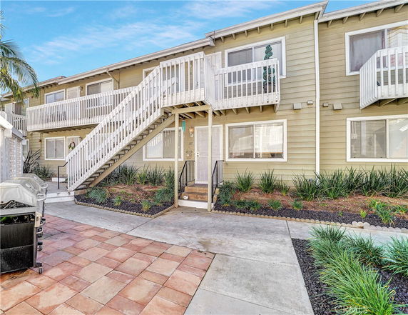 Front view of a two-story residential building with exterior stairs and balconies.