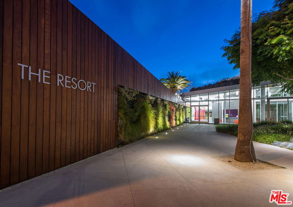 Front view of a large modern building with wood paneling and glass entrance.