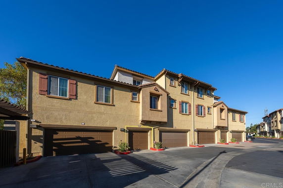 Front view of a multi-story residential building with attached garages.