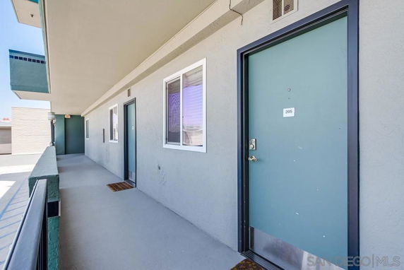 View of a building entrance with multiple doors leading to apartments.