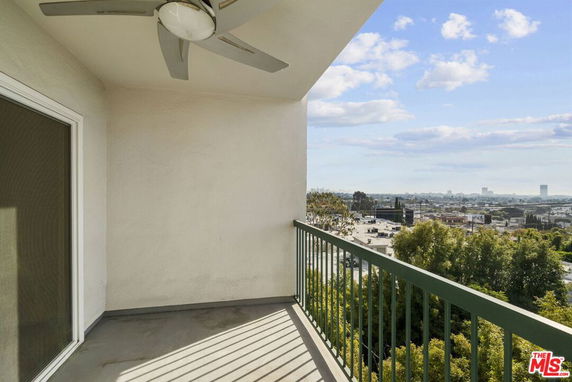 Balcony with railing overlooking cityscape and trees