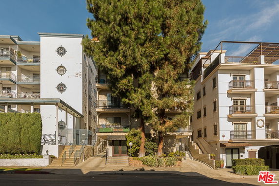 Front view of multi-story residential buildings with balconies and an entrance pathway