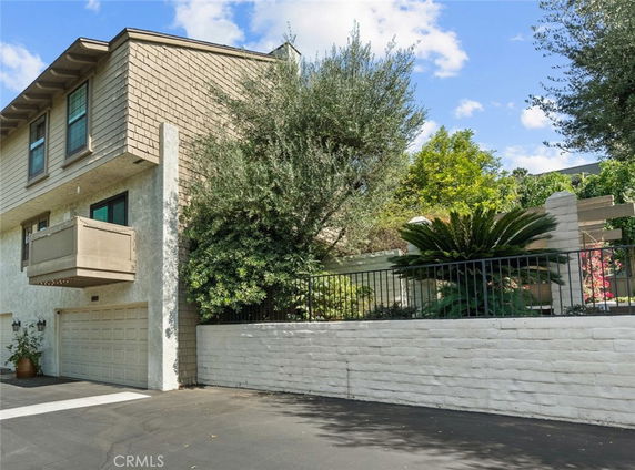 Front view of a multi-story house with a garage and balcony.