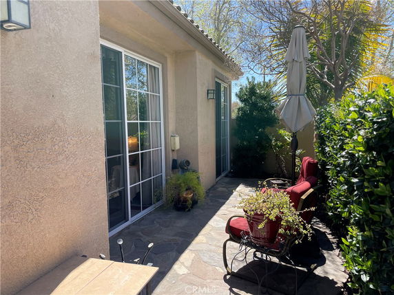 Side view of a house with a sliding glass door and outdoor seating area.