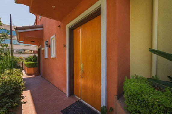Front view of a house with a wooden door and pathway.