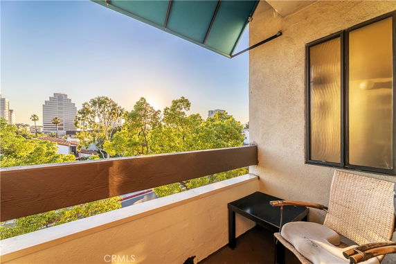 View from a balcony with cityscape and trees in the background.