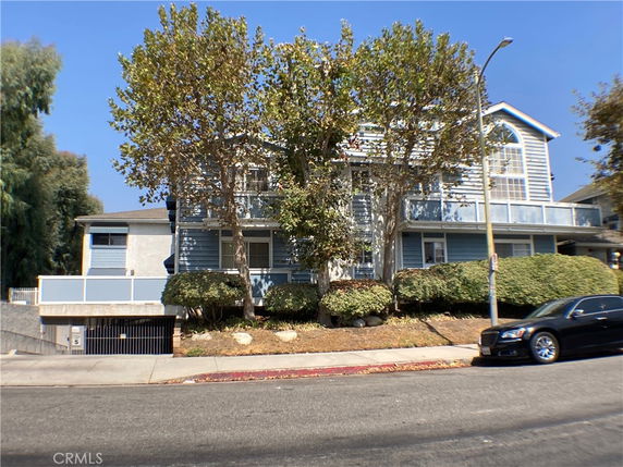 Front view of a multi-story building with blue siding and large windows.