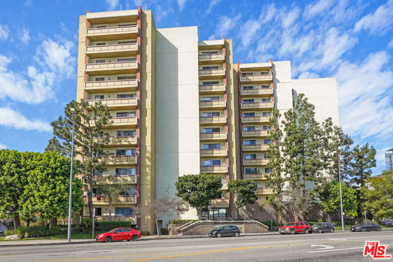Front view of a multi-story apartment building with balconies.