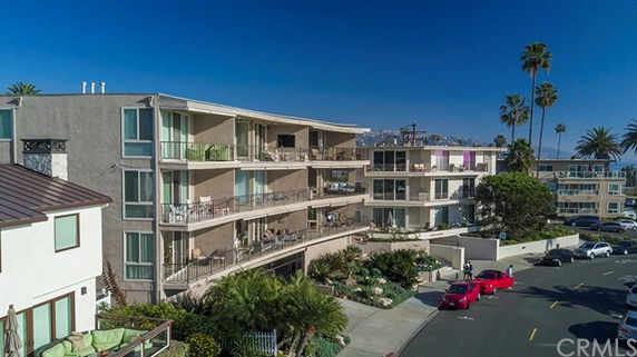 Front view of a multi-story apartment building with balconies.