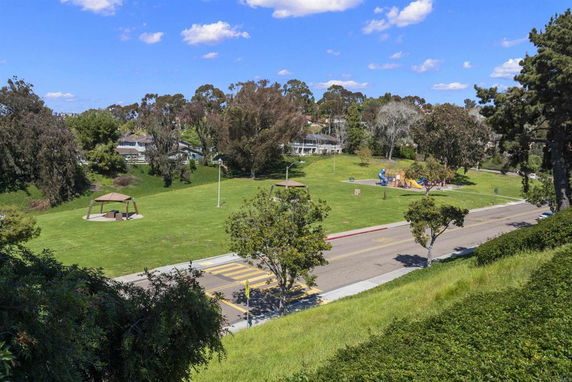 Park area with playground equipment and canopy structure.
