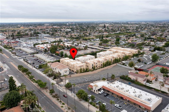 Panoramic view of a residential area with several buildings and a marker indicating a location.