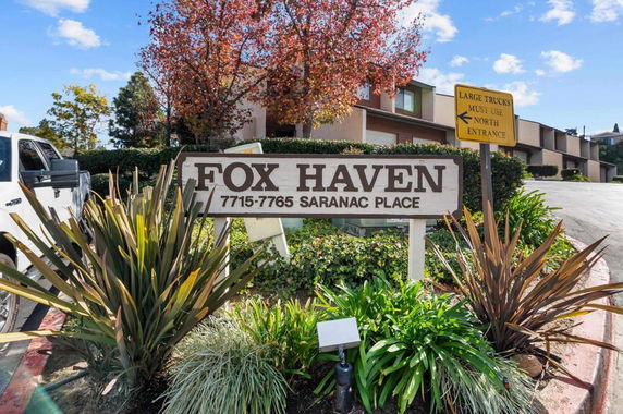 Front view of a residential complex entrance with a sign reading 'Fox Haven' and displaying the address.