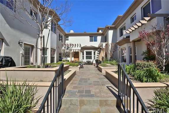 Front view of a multi-story residential complex with landscaped pathways.