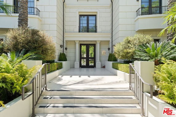 Front entrance of a multi-story building with landscaped steps.