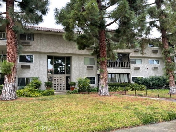 Front view of a multi-story residential building with balconies and a main entrance.
