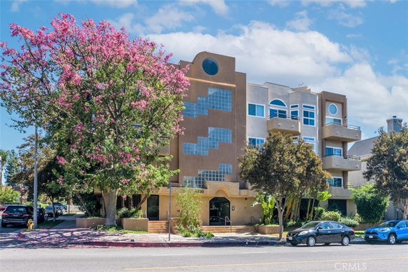 Front view of a multi-story building with modern architectural features and balconies.