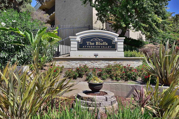 Front view of The Bluffs residential complex entrance sign with surrounding greenery.