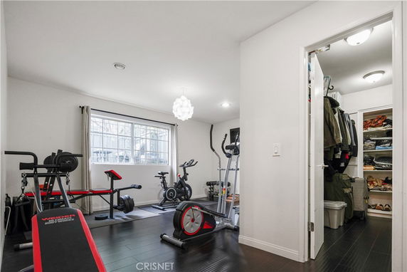 Indoor gym area with exercise equipment and an adjacent storage room.