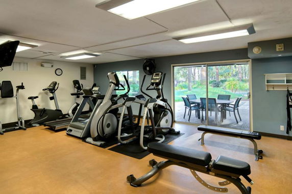 Indoor gym area with exercise equipment and large window view.