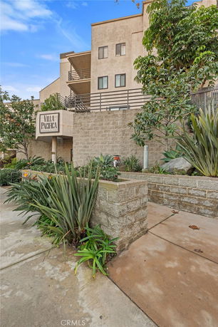 Front view of a multi-story building with balconies and a sign reading 'Villa Pacifica'.
