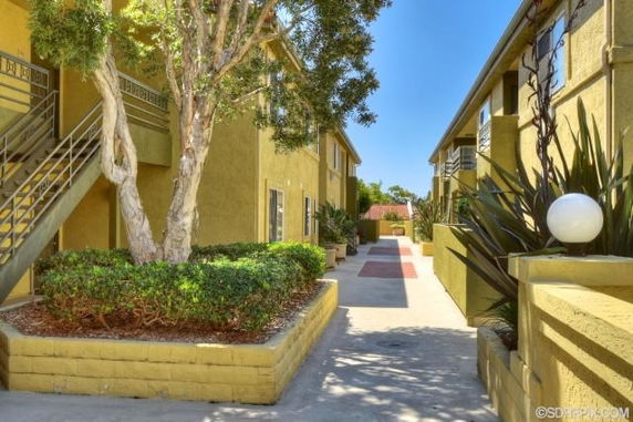 Exterior view of a two-story apartment complex with staircases and landscaping.