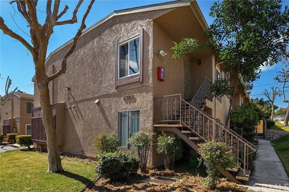 Front view of a two-story residential building with exterior stairs.
