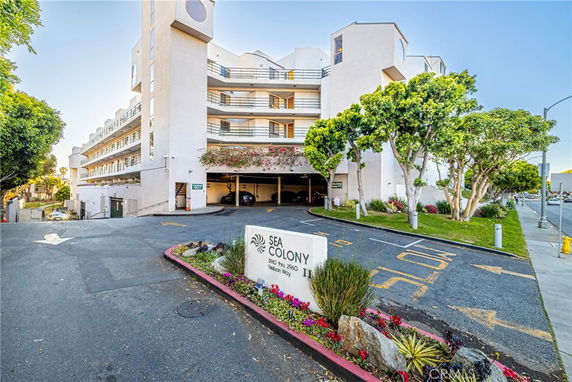 Front view of a multi-story residential building with parking entrance.