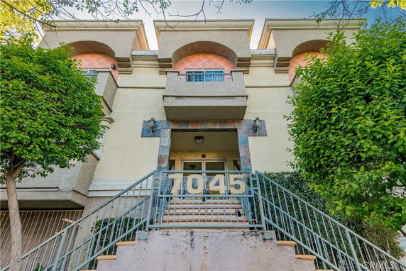 Front view of a multi-story building with a staircase leading to the entrance.