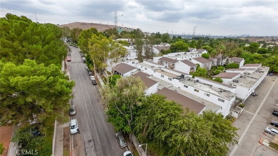 Aerial view of a residential area with trees lining the streets, showing multiple white buildings with brown roofs.