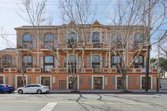 Front view of a multi-story building with arched windows and decorative facade.
