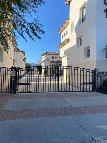 Front view of a gated apartment complex with multiple buildings.