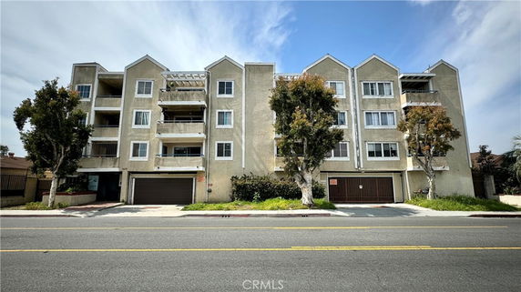 Front view of a four-story residential building with multiple balconies.