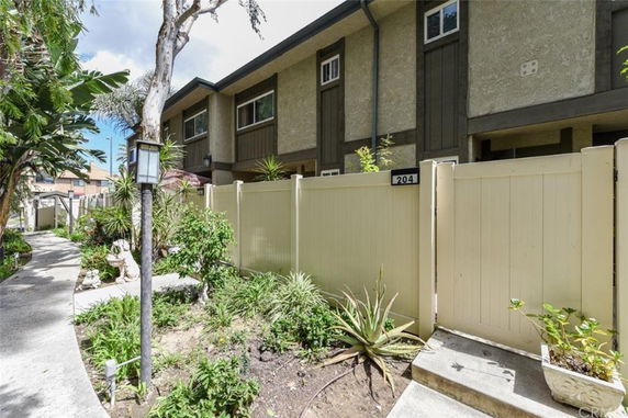 Front view of a multi-story residential building with a gated entrance.