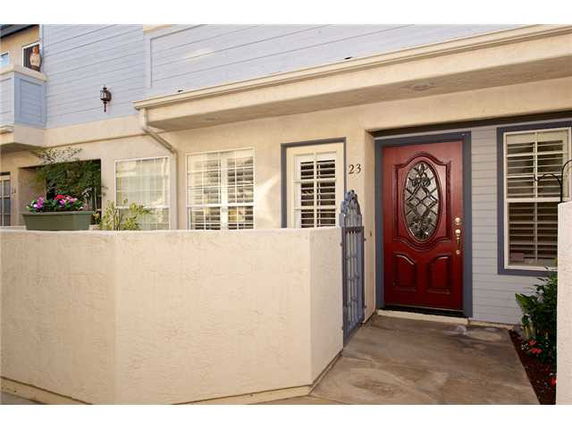 Front view of a house entrance with a red door and a small courtyard.