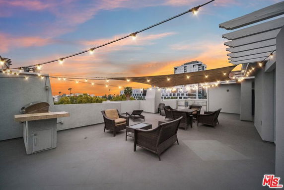 Rooftop patio with string lights and outdoor seating.